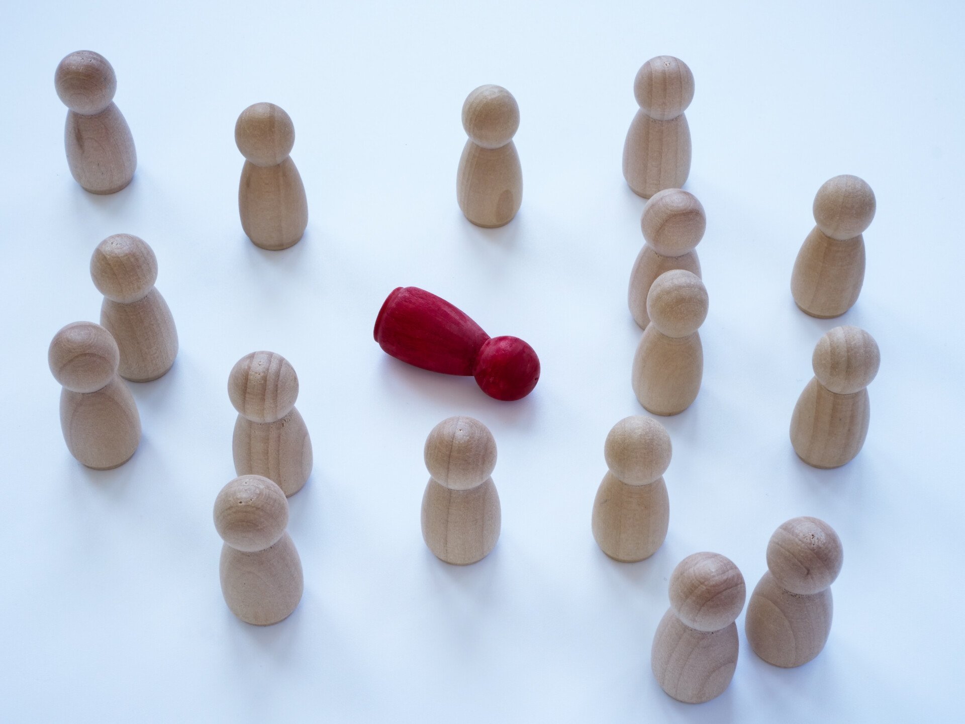 Bystander effect concept. Wooden figurines and in the middle lies red one.
