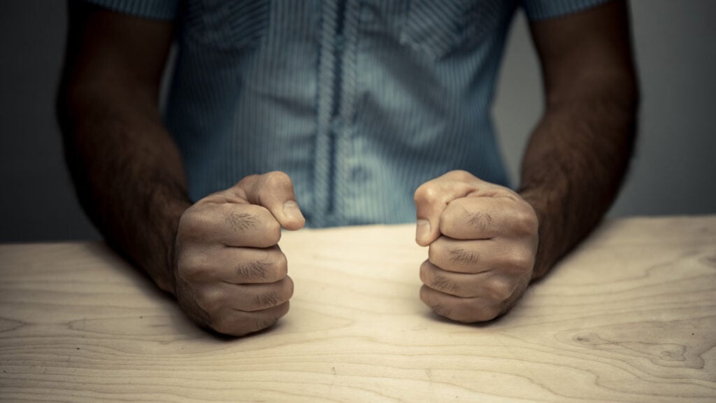 a man forming two fists on a table