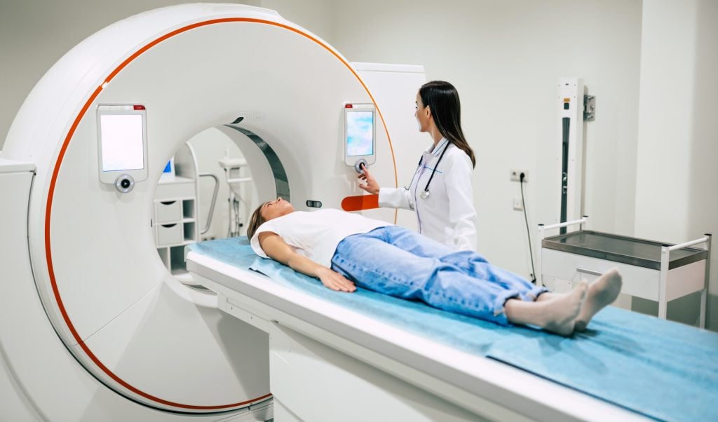 Professional Doctor Radiologist In Medical Laboratory Controls  PET Scan with Female Patient Undergoing